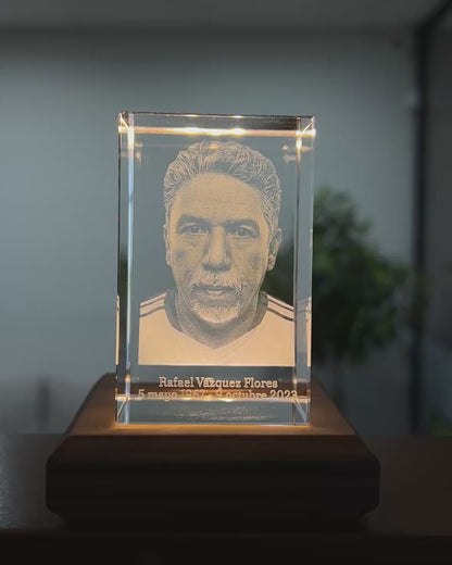 Cubo de cristal 3D con retrato grabado girando en la mano para mostrar el efecto 3D y su tamaño real